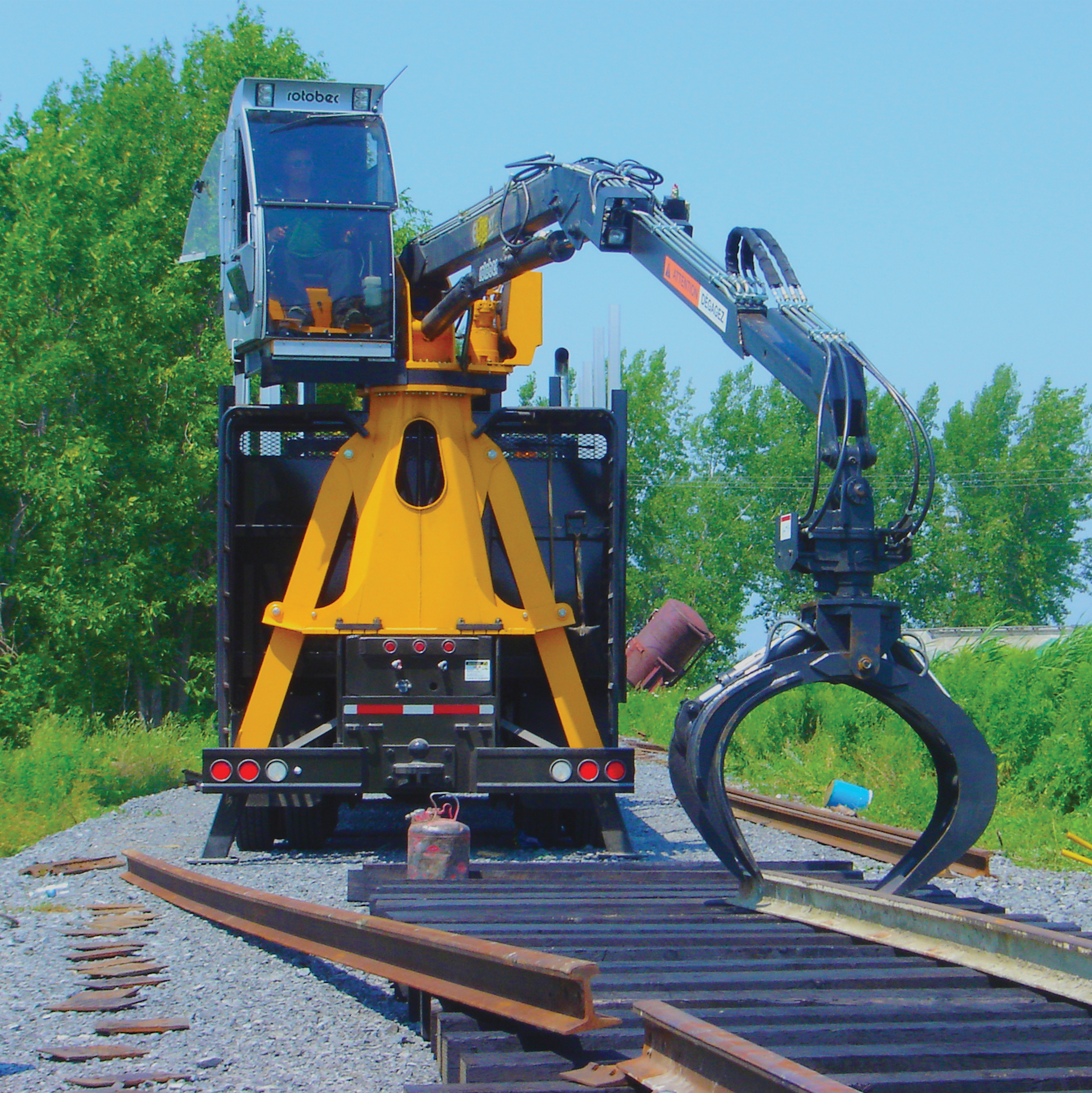 Rotobec knuckleboom mounted on a truck loader laying down a train track.