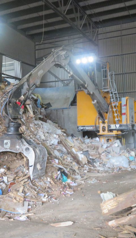 Loader with a Rotobec waste grapple in a pile of recyclable material.