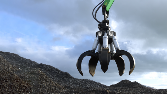 Orange peel grapple grabbing a pile of big metal scraps.