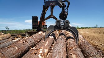 Rotobec log grapple picking up logs from a pile of logs.