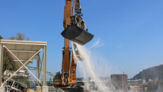 Outside view of a loader where the Rotobec clam bucket is filled with sand in movement.