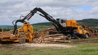 Rotobec log grapple depositing logs in a trailer.
