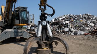 Rotobec scrap grapple on the ground in a scrap yard.