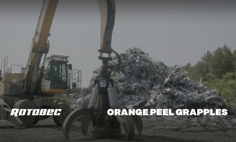 Loader with a Rotobec orange peel grapple in front of a bunch of recyclable material.