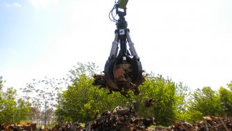 Orange peel grapple grabbing a big amount of scrap metal.