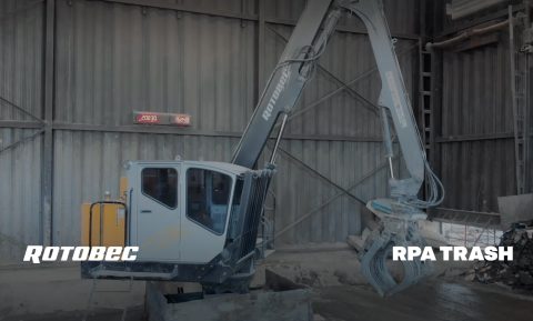 Trash grapple loaders with a pile of waste material in a warehouse.