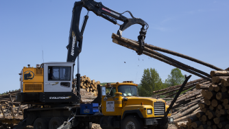 The Evolution 960 diesel loader lifting logs.
